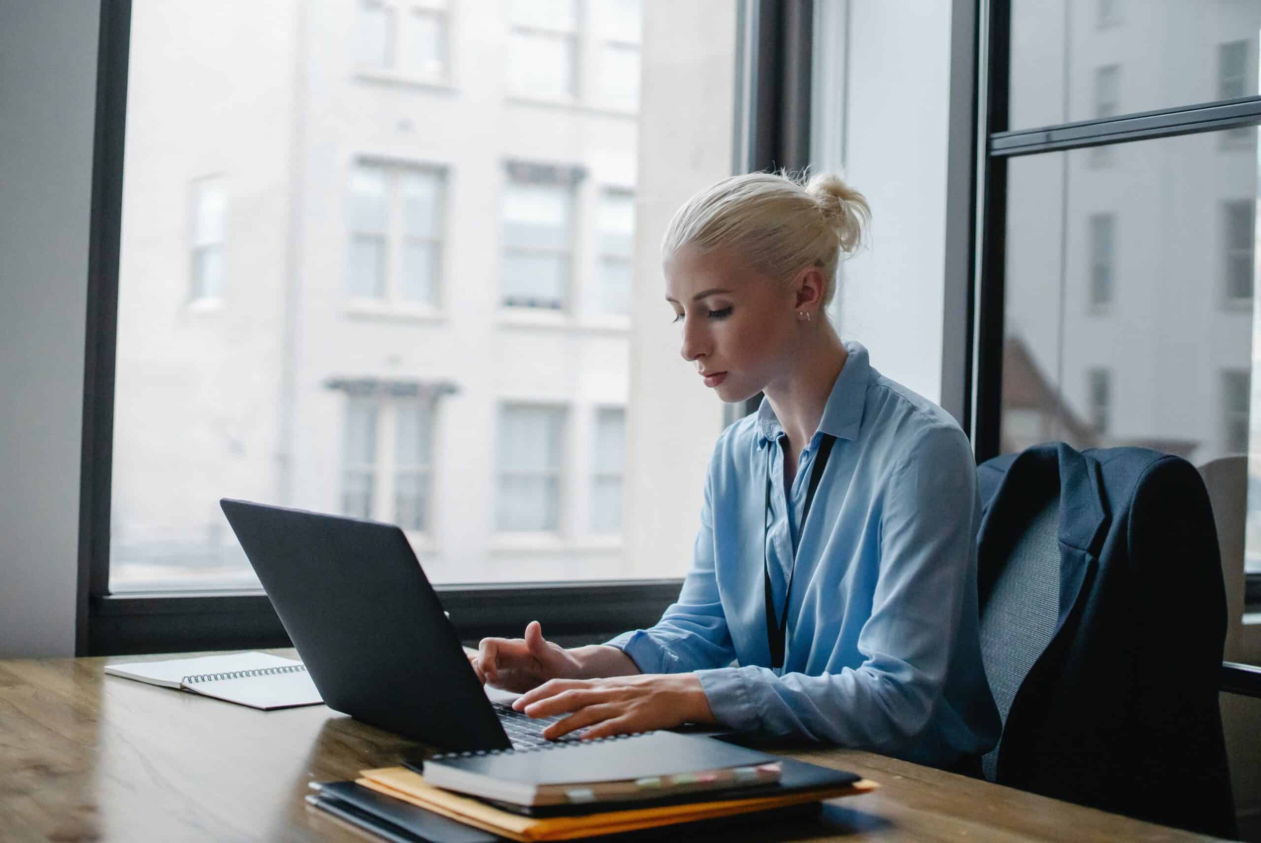 Photo of a female sitting at a desk on her laptop.